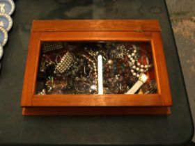 A QUANTITY OF COSTUME JEWELLERY IN A GLASS TOPPED DISPLAY CASE