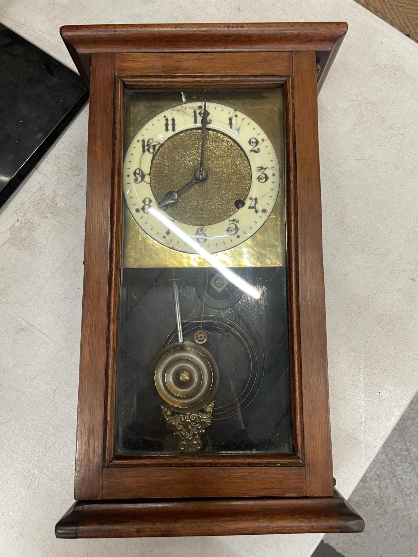 AN OAK CASE CHIMING WALL CLOCK