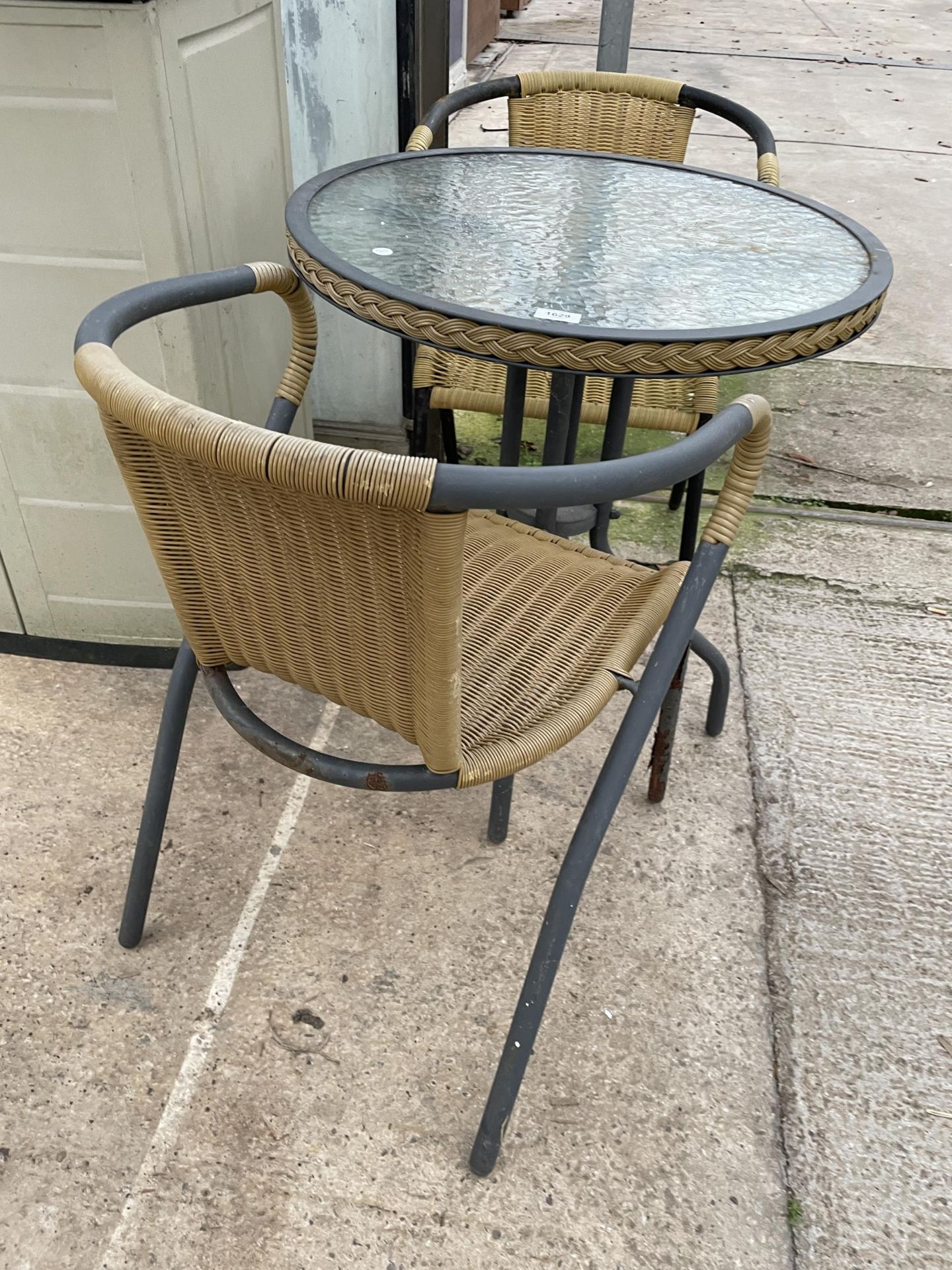 A GLASS TOPPED BISTRO TABLE AND TWO RATTAN EFFECT CHAIRS - Image 3 of 3
