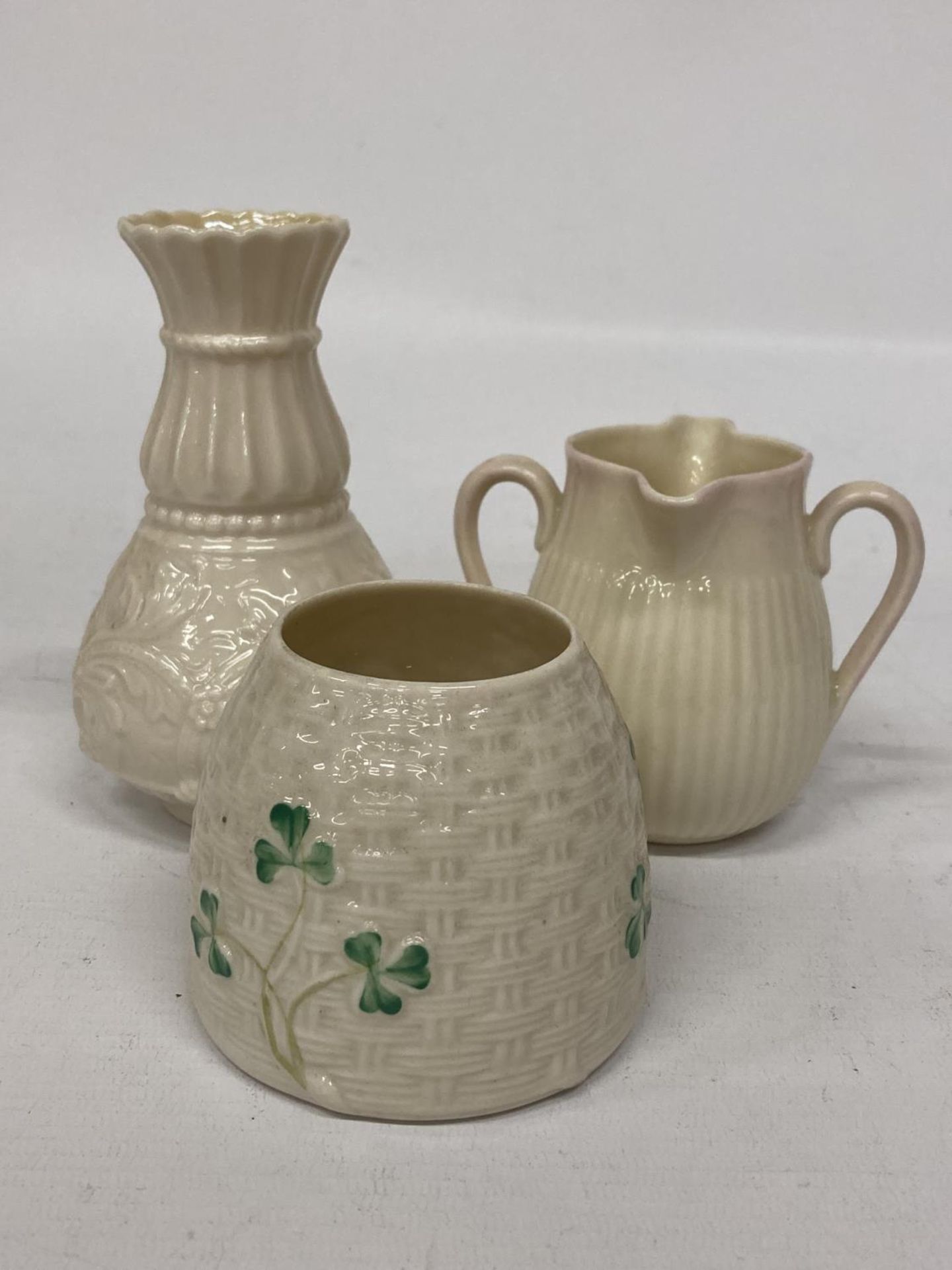 A BELLEEK LILY OF THE VALLEY SPILL VASE TOGETHER WITH A DOUBLE SPOUT CREAMER AND SHAMROCK POT