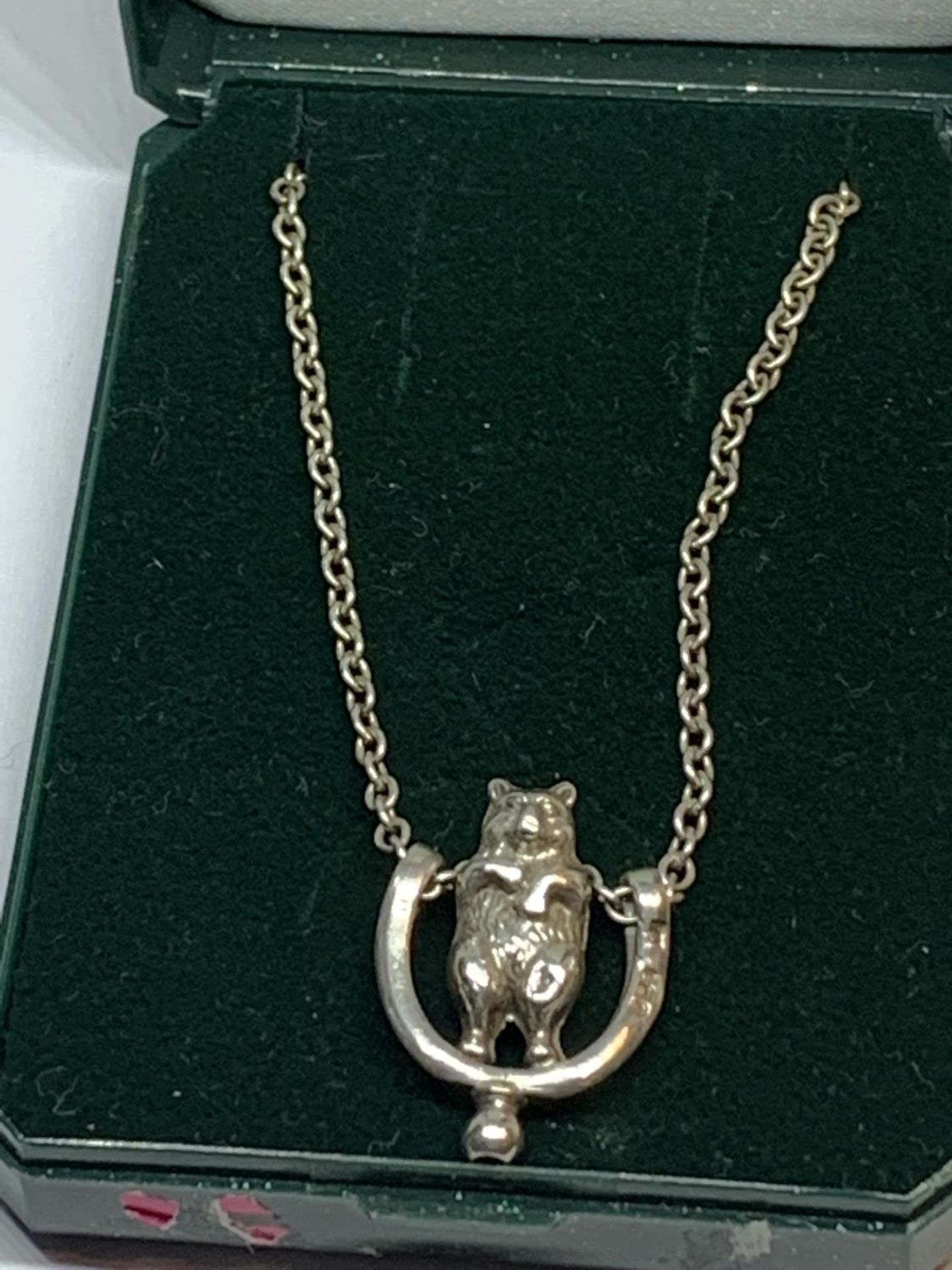 A SILVER NECKLACE WITH BEAR PENDANT IN A PRESENTATION BOX