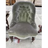 A VICTORIAN BUTTON-BACK LOW LOUNGE CHAIR ON TURNED FRONT LEGS, WITH PORCELAIN CASTERS