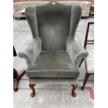 A PARKER KNOLL WINGED FIRESIDE CHAIR ON FRONT CABRIOLE LEGS (M.P.K. 1140)