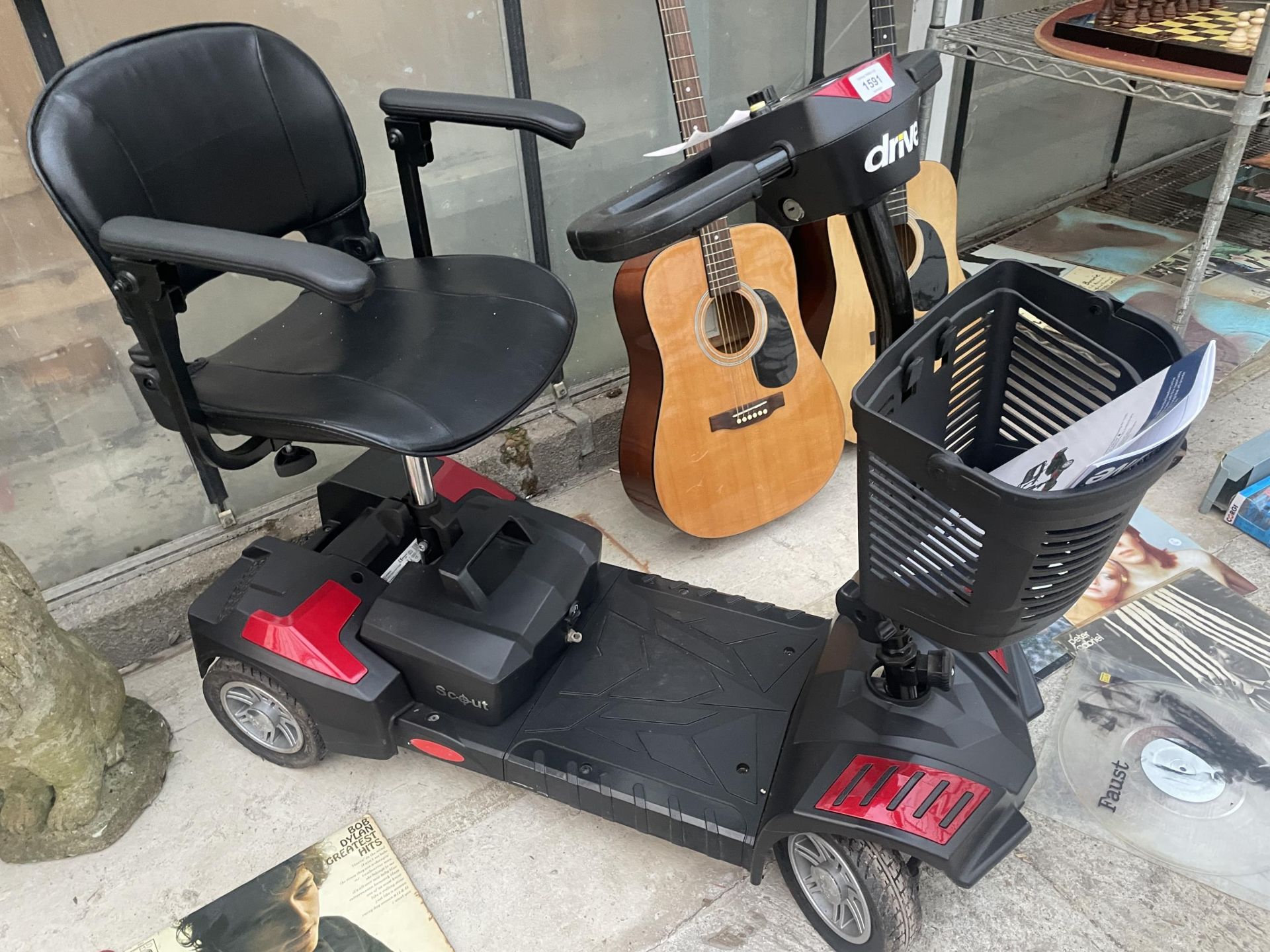 A DRIVE MOBILITY SCOOTER WITH KEY AND CHARGER IN THE OFFICE