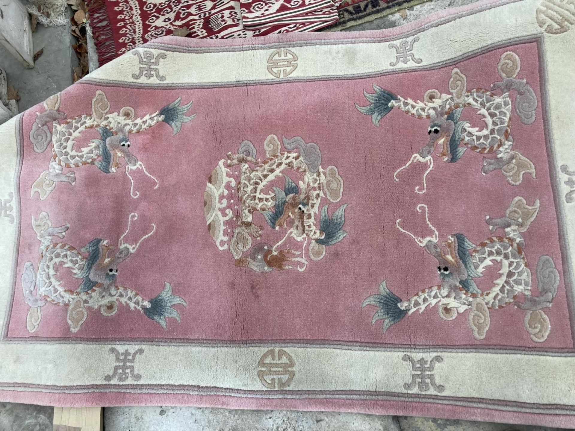 A PINK PATTERNED FRINGED RUG AND A SMALL RED PATTERNED RUG - Image 2 of 2