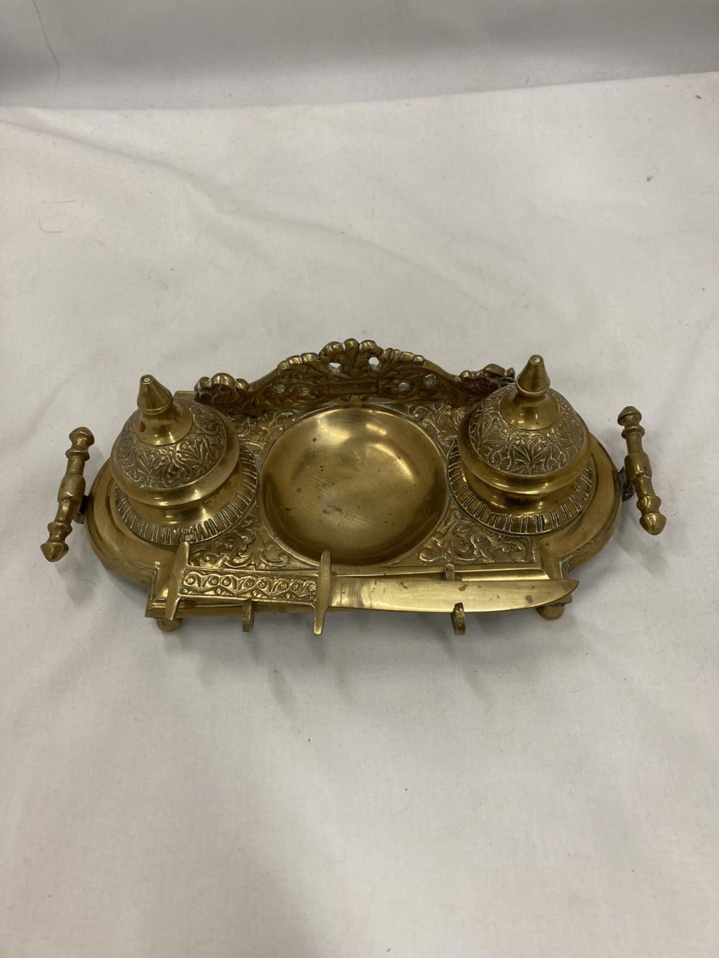 AN ORNATE VINTAGE BRASS INKWELL STAND