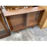 A RETRO TEAK BOOKCASE WITH TWO SLIDING GLASS DOORS, 43" WIDE
