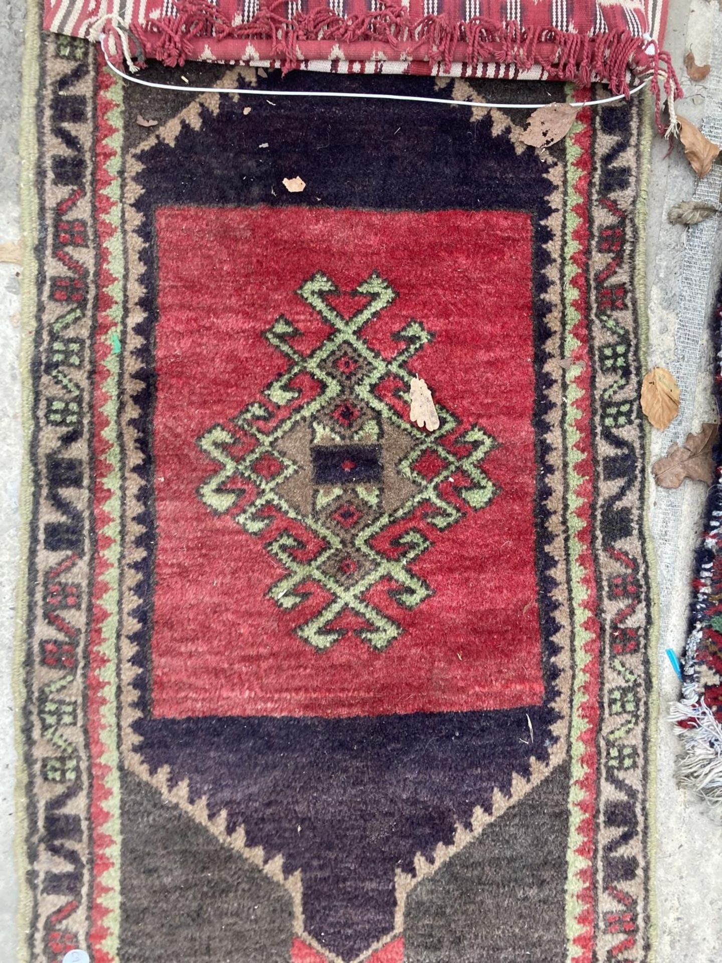 A SMALL RED PATTERNED FRINGED RUG AND A SMALL RED PATTERNED WALL HANGING - Bild 2 aus 3