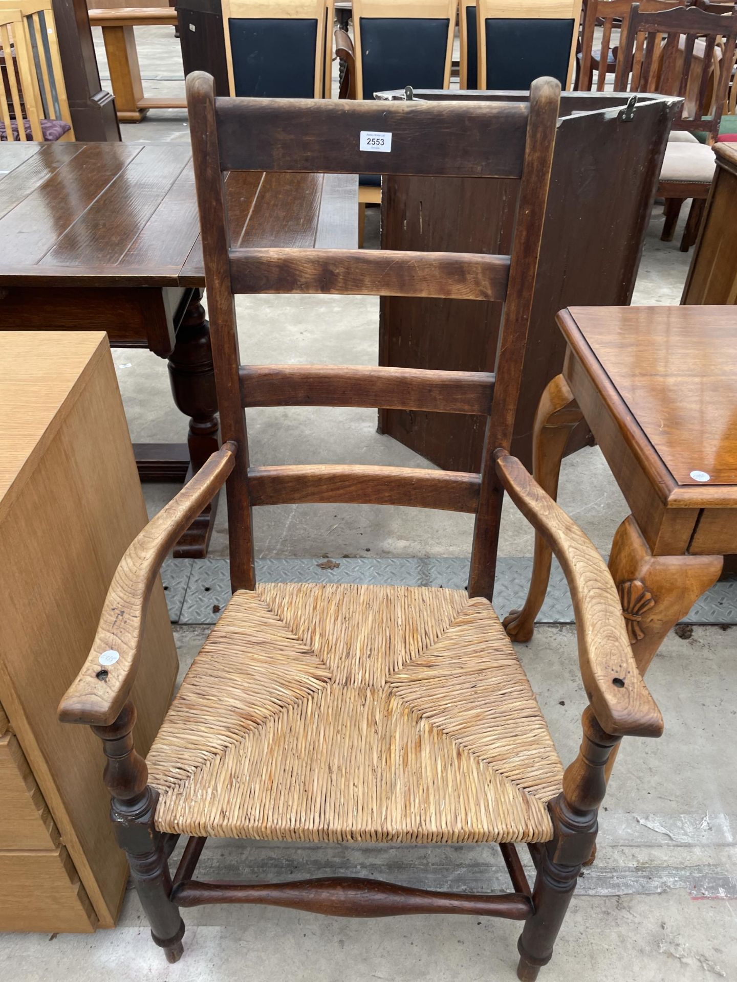 A 19TH CENTURY LADDERBACK ELBOW CHAIR WITH RUSH SEAT