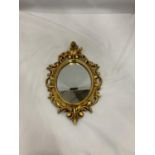 A SMALL OVAL GILT MIRROR, PLEASE NOTE THE SIZE, 19CM X 29CM