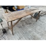 A WOODEN FOLDING TRESTLE TABLE