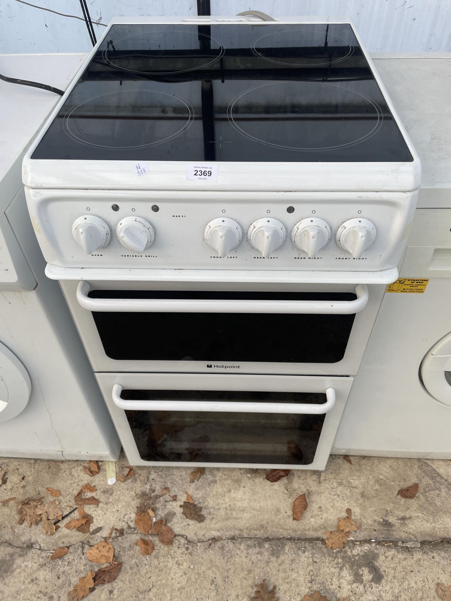 A BLACK AND WHITE HOTPOINT ELECTRIC FREESTANDING OVEN AND HOB