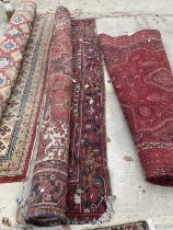 A LARGE RED PATTERNED FRINGED RUG