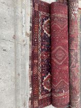 A LARGE RED PATTERNED FRINGED RUG