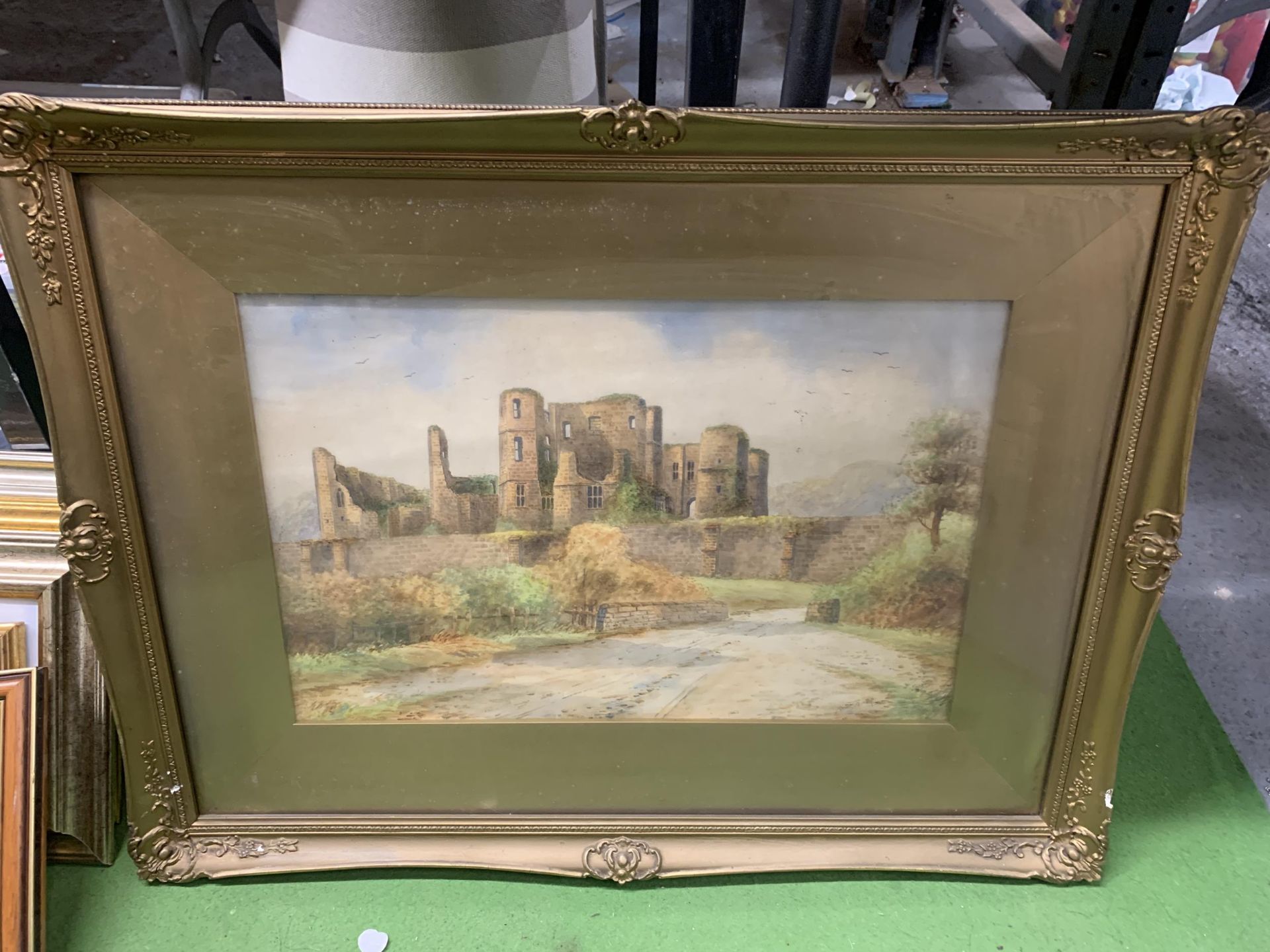 A FRAMED WATERCOLOUR ON BOARD OF A RUIN OF A CASTLE WITH SIGNATURE