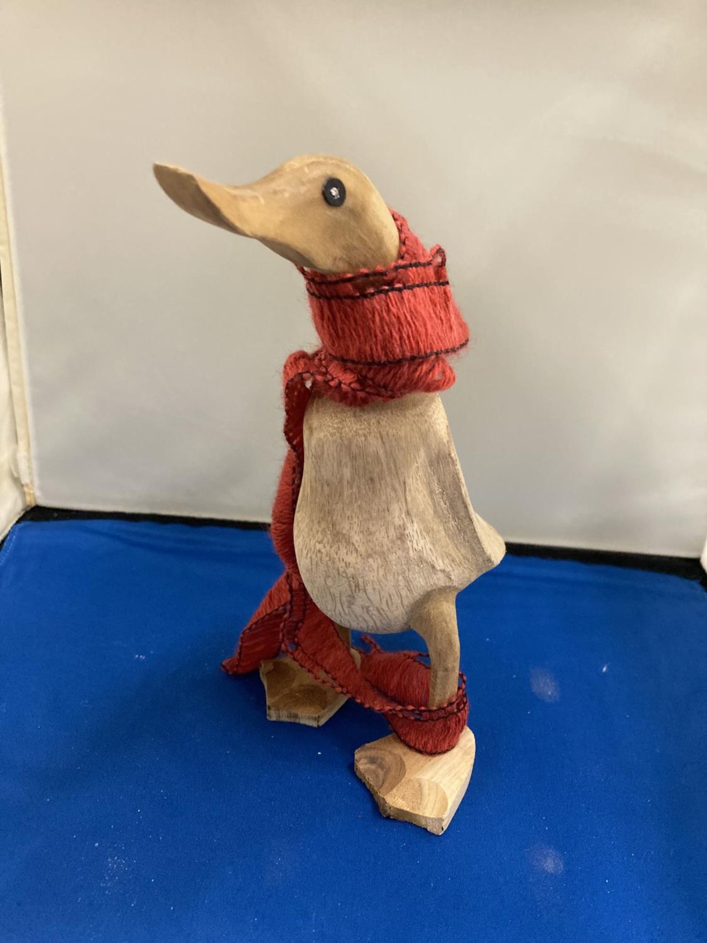 A CARVED WOODEN DUCK WEARING A SCARF, HEIGHT 22CM