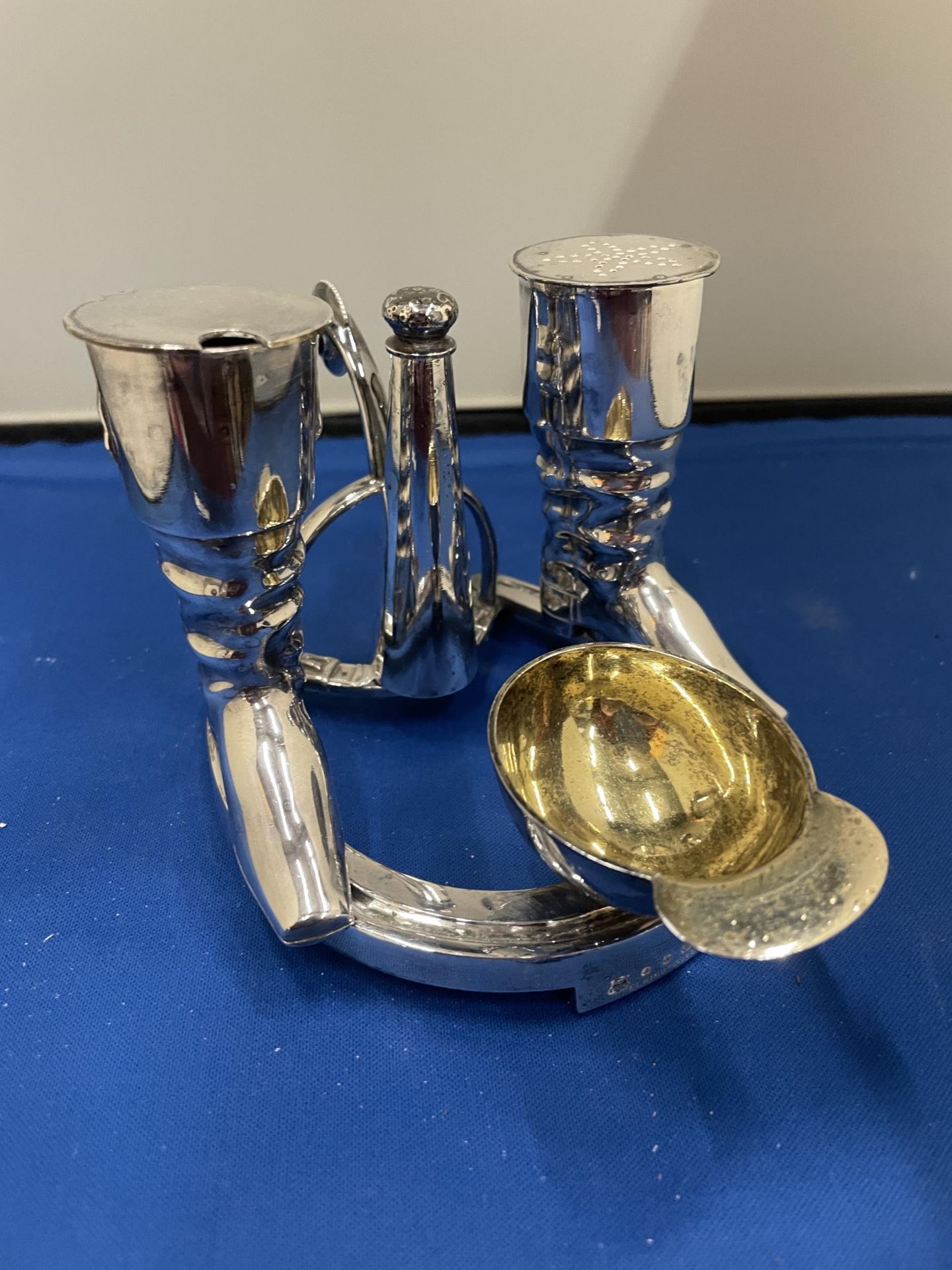 AN ELKINGTON SILVER PLATED CRUET SET IN THE GUISE OF RIDING BOOTS AND HAT ST ON A HORSE SHOE BASE