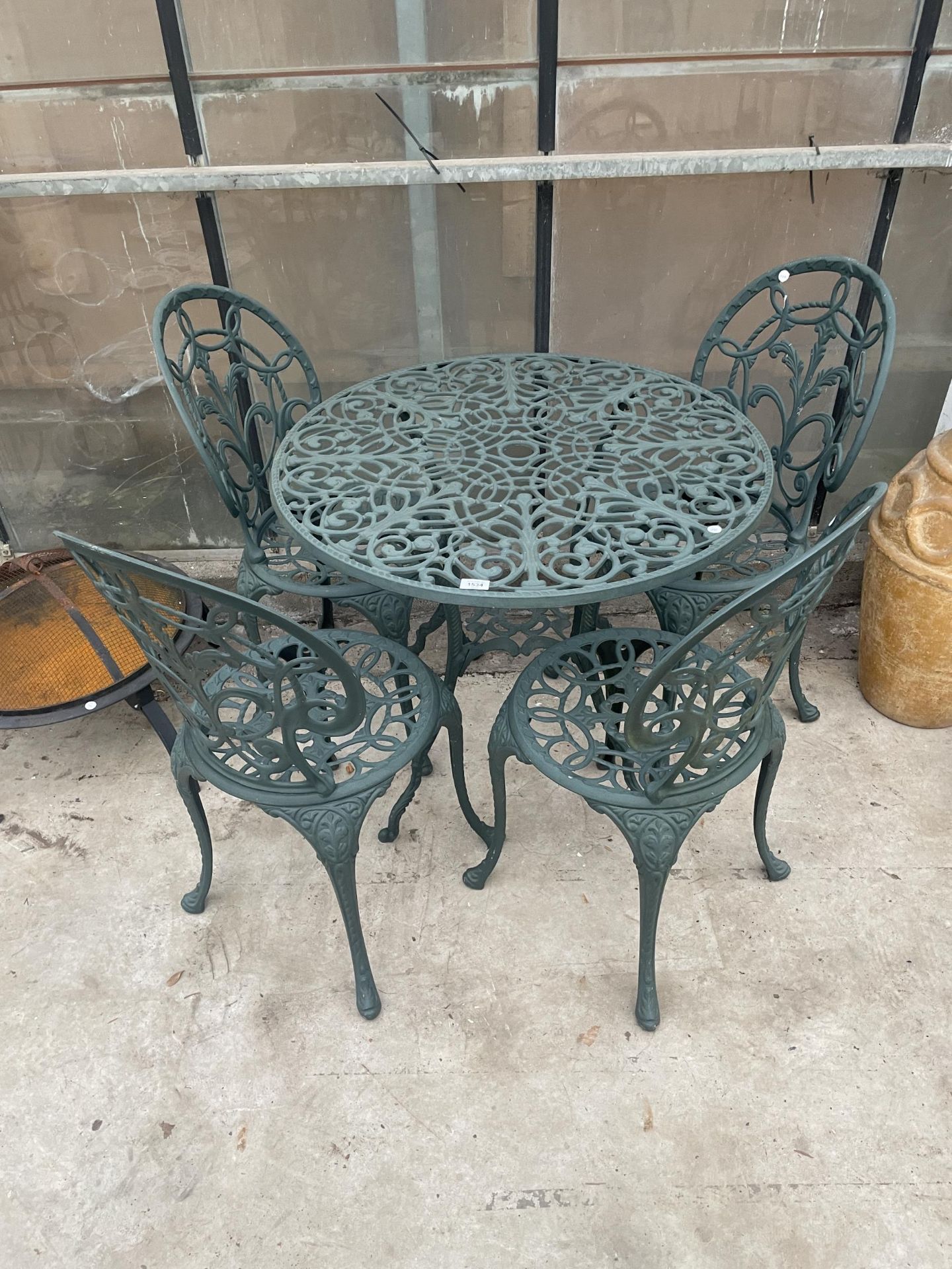 A VINTAGE STYLE GARDEN BISTRO SET COMPRISING OF A ROUND TABLE AND FOUR CHAIRS