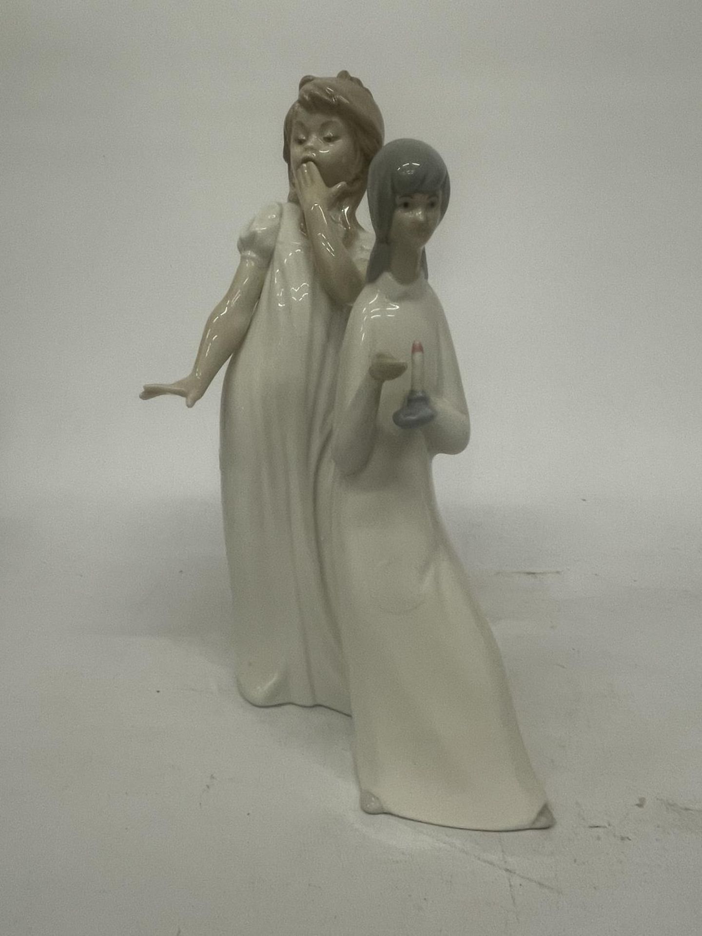 A NAO FIGURE OF A GIRL YAWNING TOGETHER WITH A MIQUEL REQUENA S.A. FIGURE OF A GIRL HOLDING A CANDLE