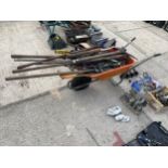 AN ORANGE PLASTIC WHEEL BARROW WITH A LARGE ASSORTMENT OF GARDEN TOOLS TO INCLUDE SPADES, FORKS