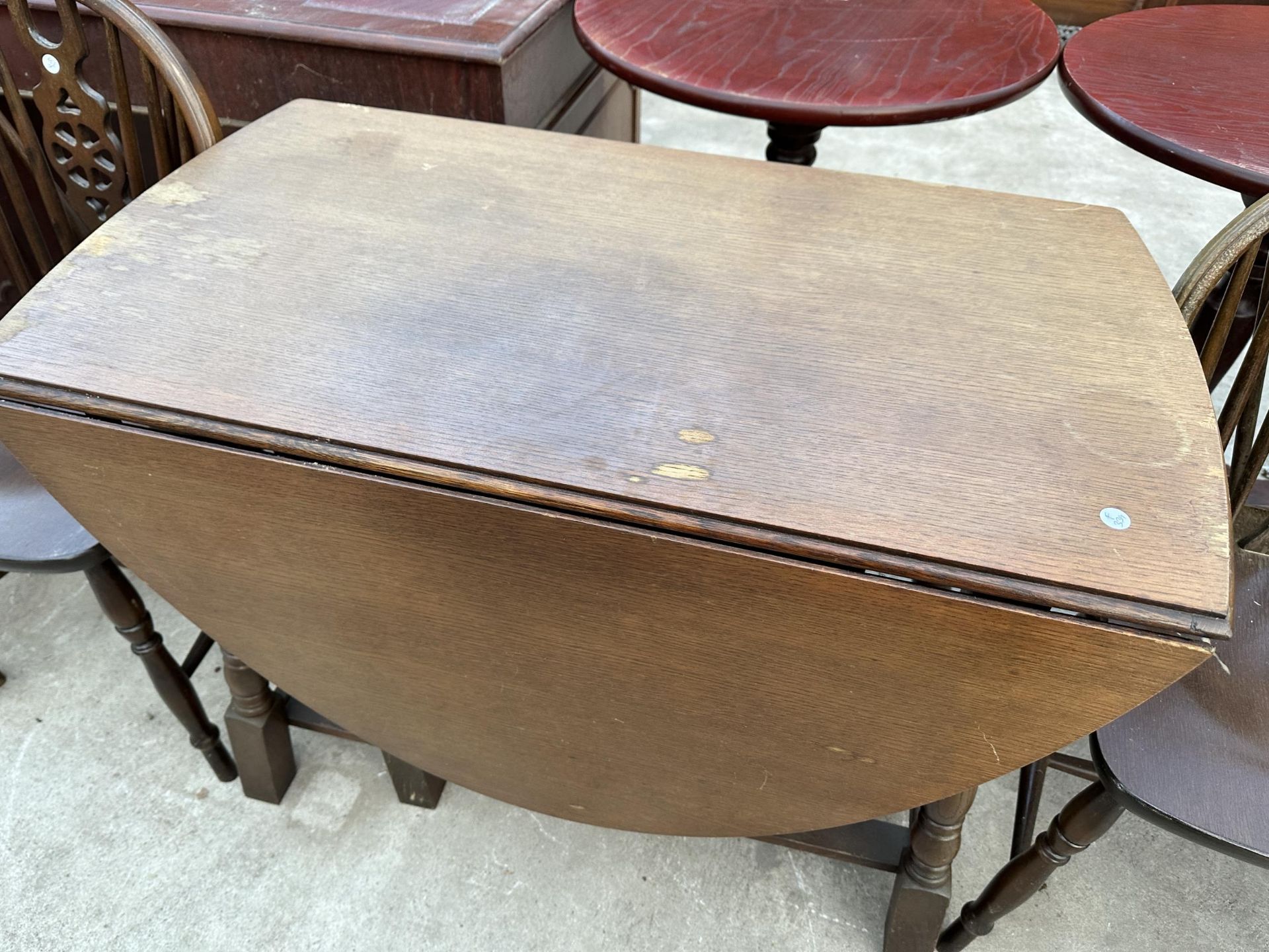 AN OVAL OAK GATELEG DINING TABLE 59" X38" OPENED AND FOUR WHEEL BACK WINDSOR STYLE CHAIRS - Image 4 of 7