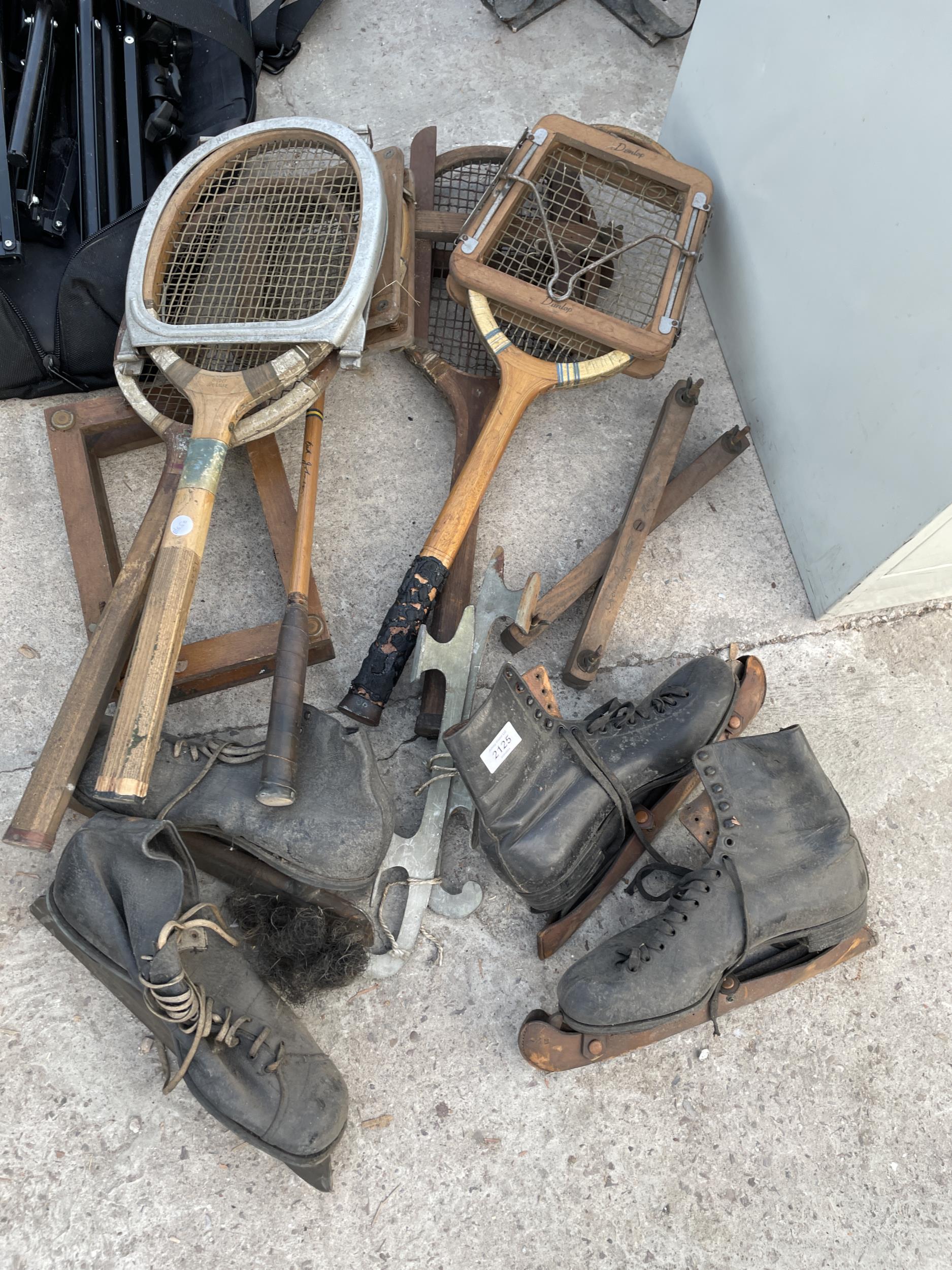 AN ASSORTMENT OF VINTAGE SPORTS EQUIPMENT TO INCLUDE TENNIS RACKETS AND ICE SKATES ETC