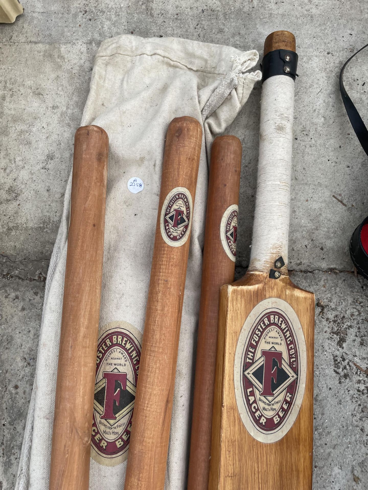 A VINTAGE WOODEN 'FOSTER BREWING CO.' CRICKET BAT AND STUMPS - Image 2 of 2