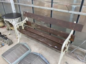 A VINTAGE WOODEN PLANK GARDEN BENCH WITH DECORATIVE CAST BENCH ENDS