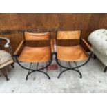 A PAIR OF WROUGHT IRON CAMPAIGN STYLE CHAIRS ON X FRAMES WITH LEATHER SEATS, BACKS AND ARMS