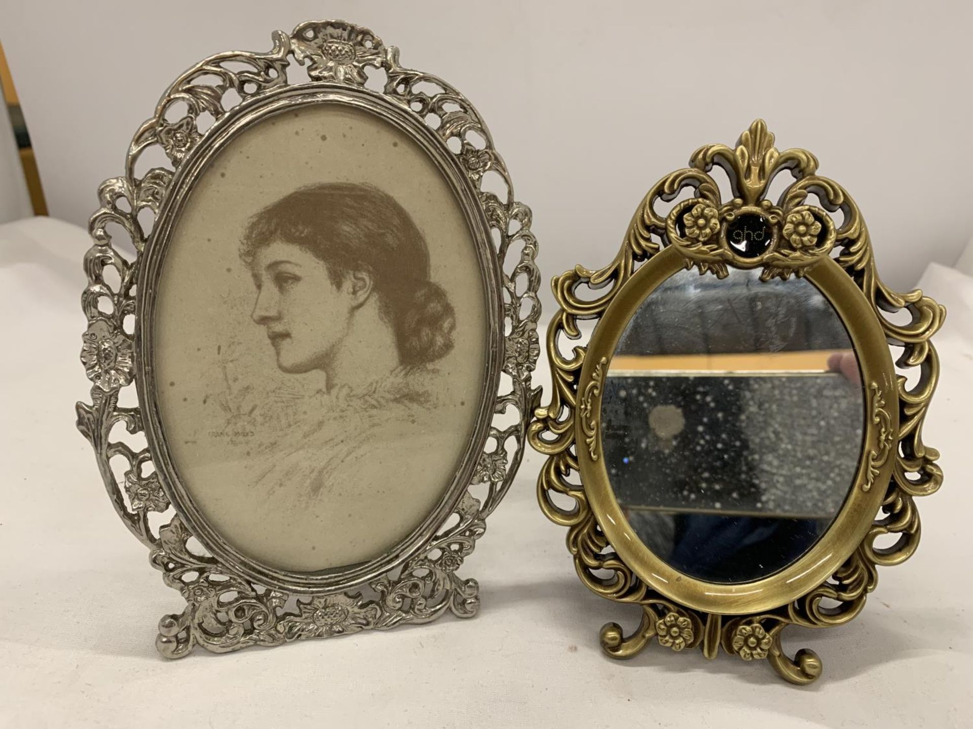 A SMALL GILT FRAMED MIRROR AND A SILVER COLOURED PHOTO FRAME