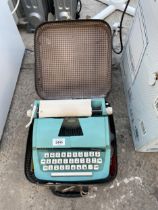 A PETITE JUNIOR PORTABLE TYPEWRITER WITH CARRY CASE