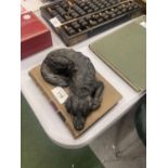A HEAVY MODEL OF A SLEEPING DOG ON A STONEWARE BOOK, LENGTH 18CM, HEIGHT 7CM