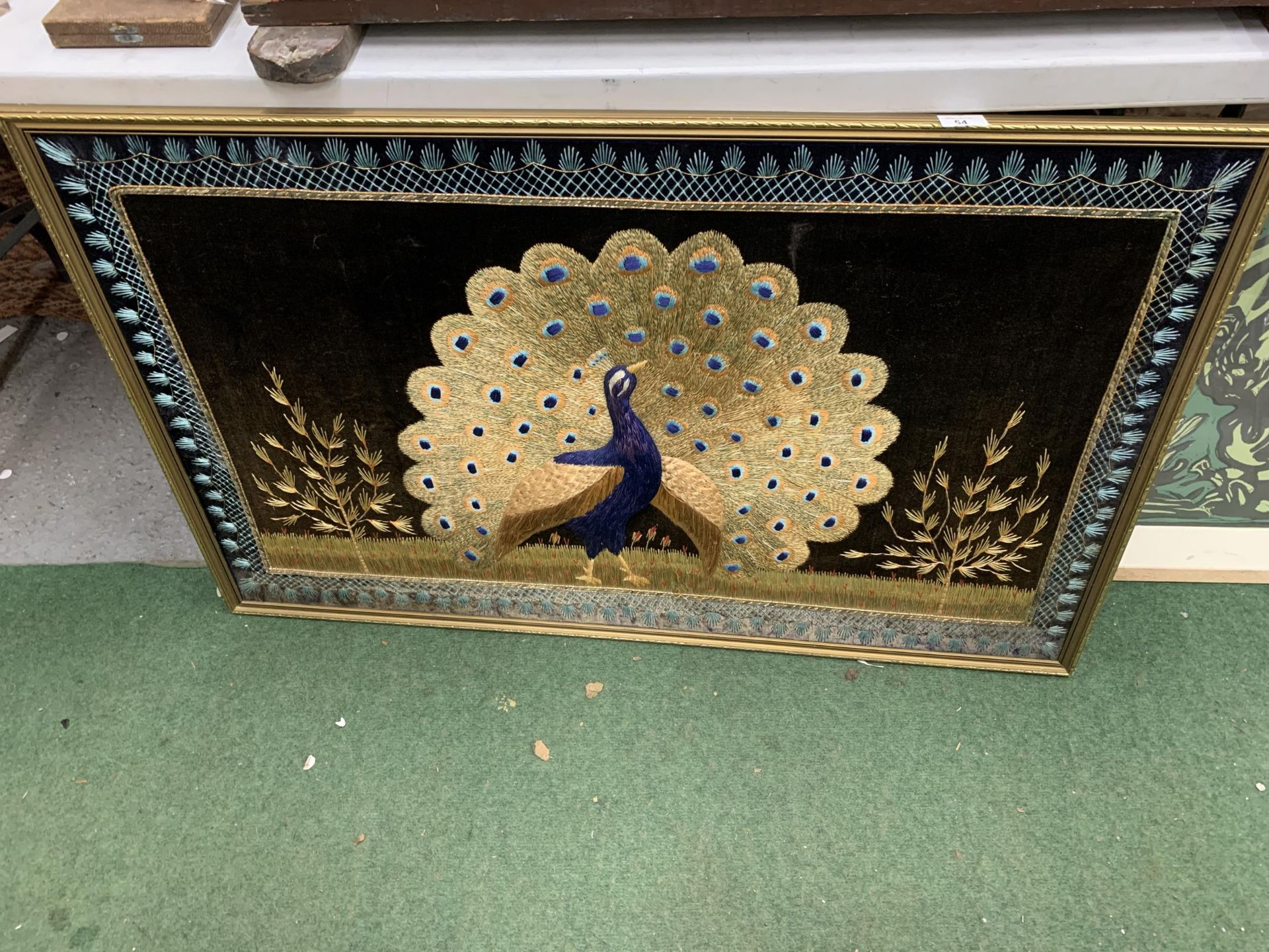 A LARGE GILT FRAMED EMBROIDERED COLLAGE OF A PEACOCK