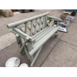 A RUSTIC WOODEN THREE SEATER GARDEN BENCH