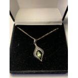 A SILVER PERIDOT NECKLACE IN A PRESENTATION BOX