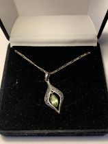 A SILVER PERIDOT NECKLACE IN A PRESENTATION BOX