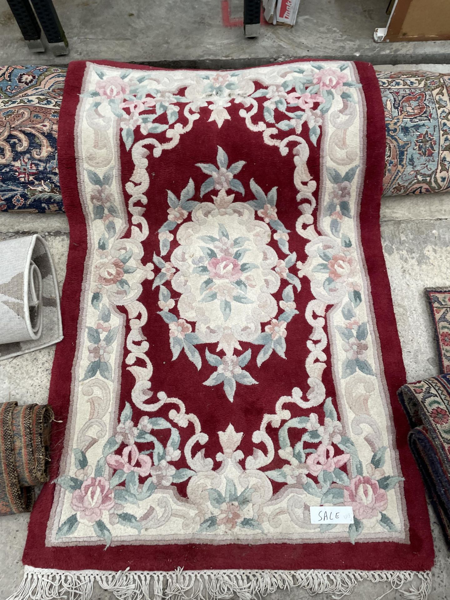 A SMALL RED PATTERNED FRINGED RUG - Image 2 of 2