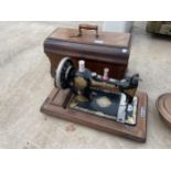 A VINTAGE JONES SEWING MACHINE WITH WOODEN CARRY CASE