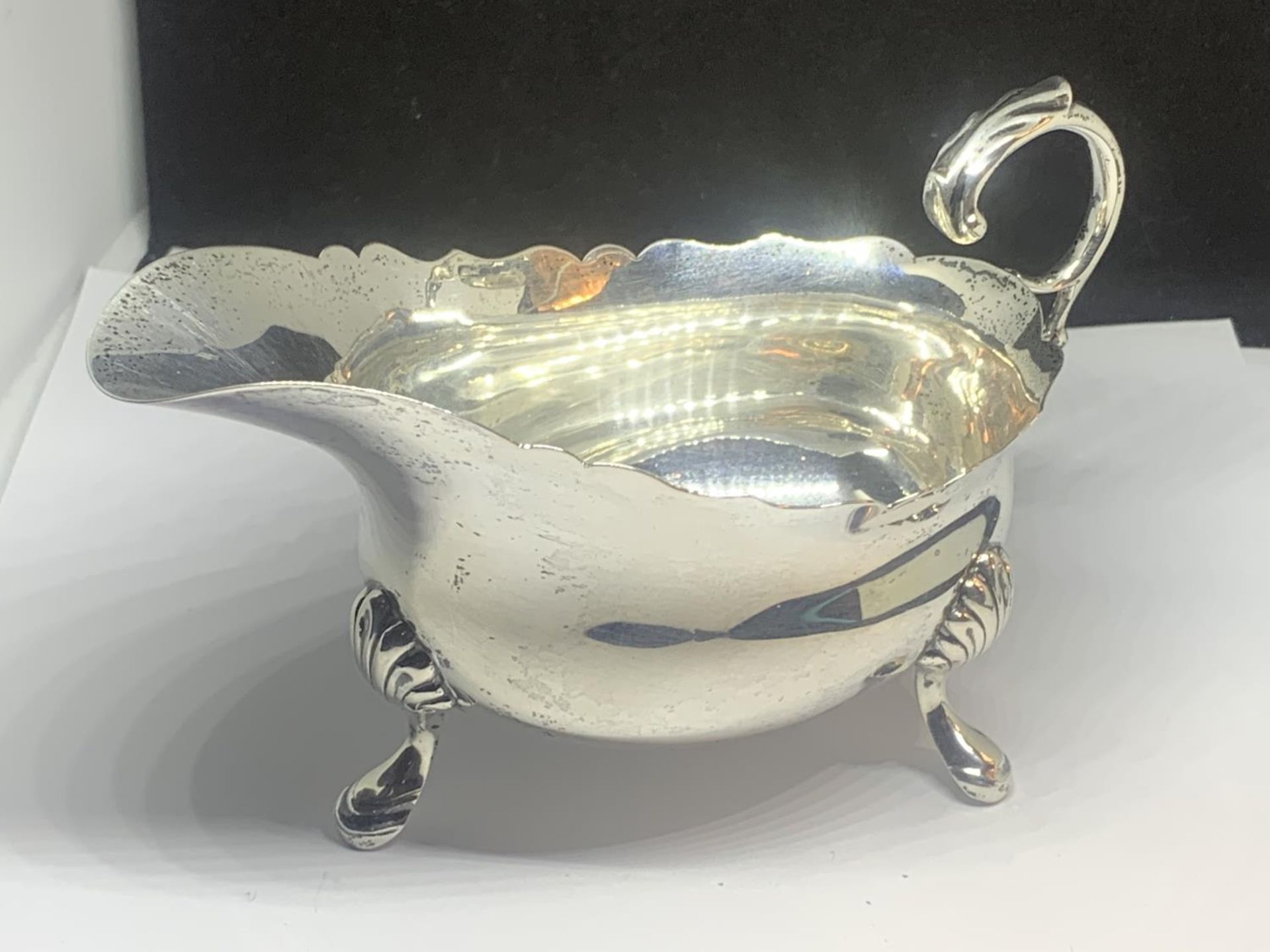 A HALLMARKED LONDON SILVER THREE LEGGED JUG