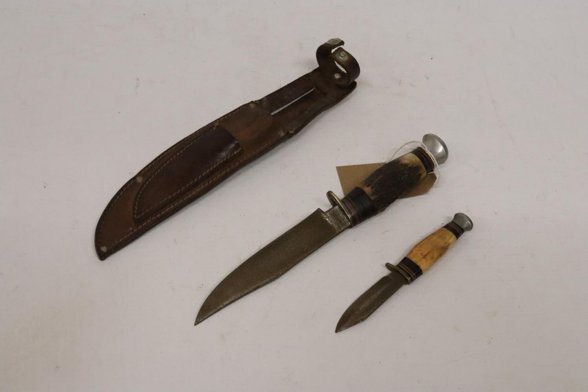 A TWIN KNIFE AND LEATHER SCABBARD, BLADES 13 AND 6CM