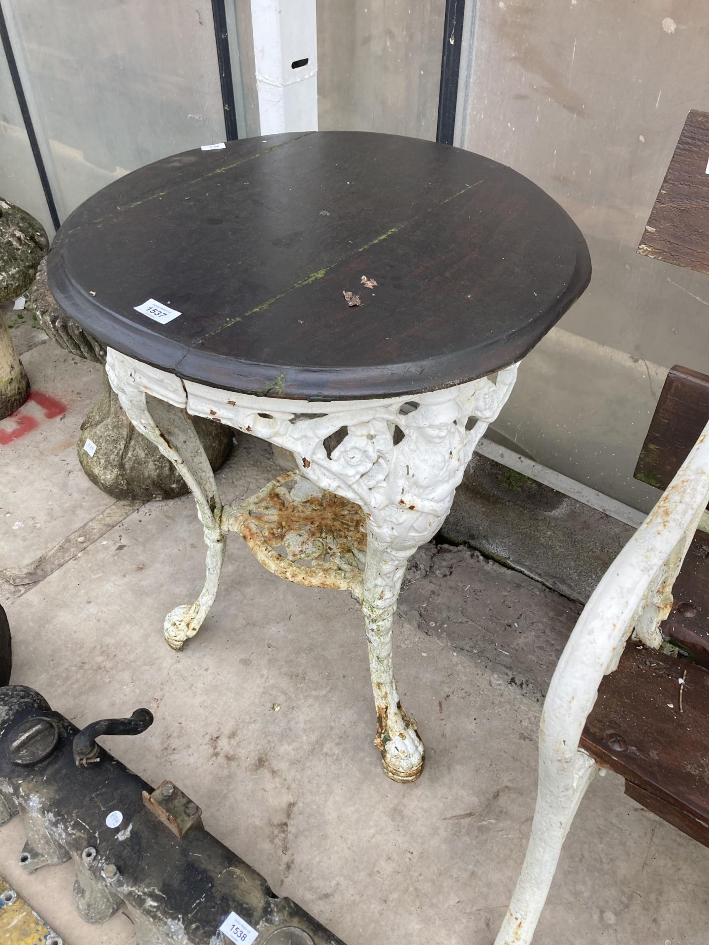 A VINTAGE PUB TABLE WITH CAST IRON BASE AND WOODEN TOP