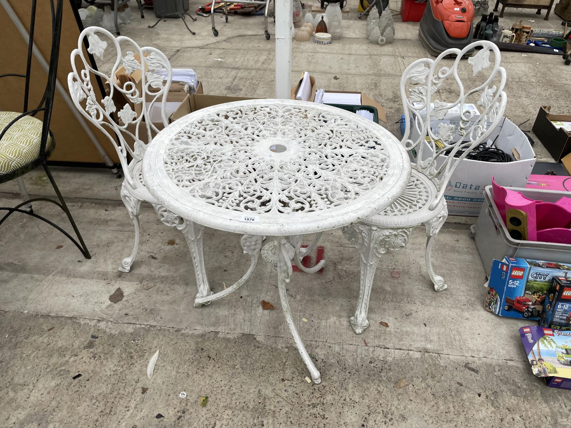 A VINTAGE CAST ALLOY BISTRO SET COMPRISING OF A ROUND TABLE AND TWO CHAIRS