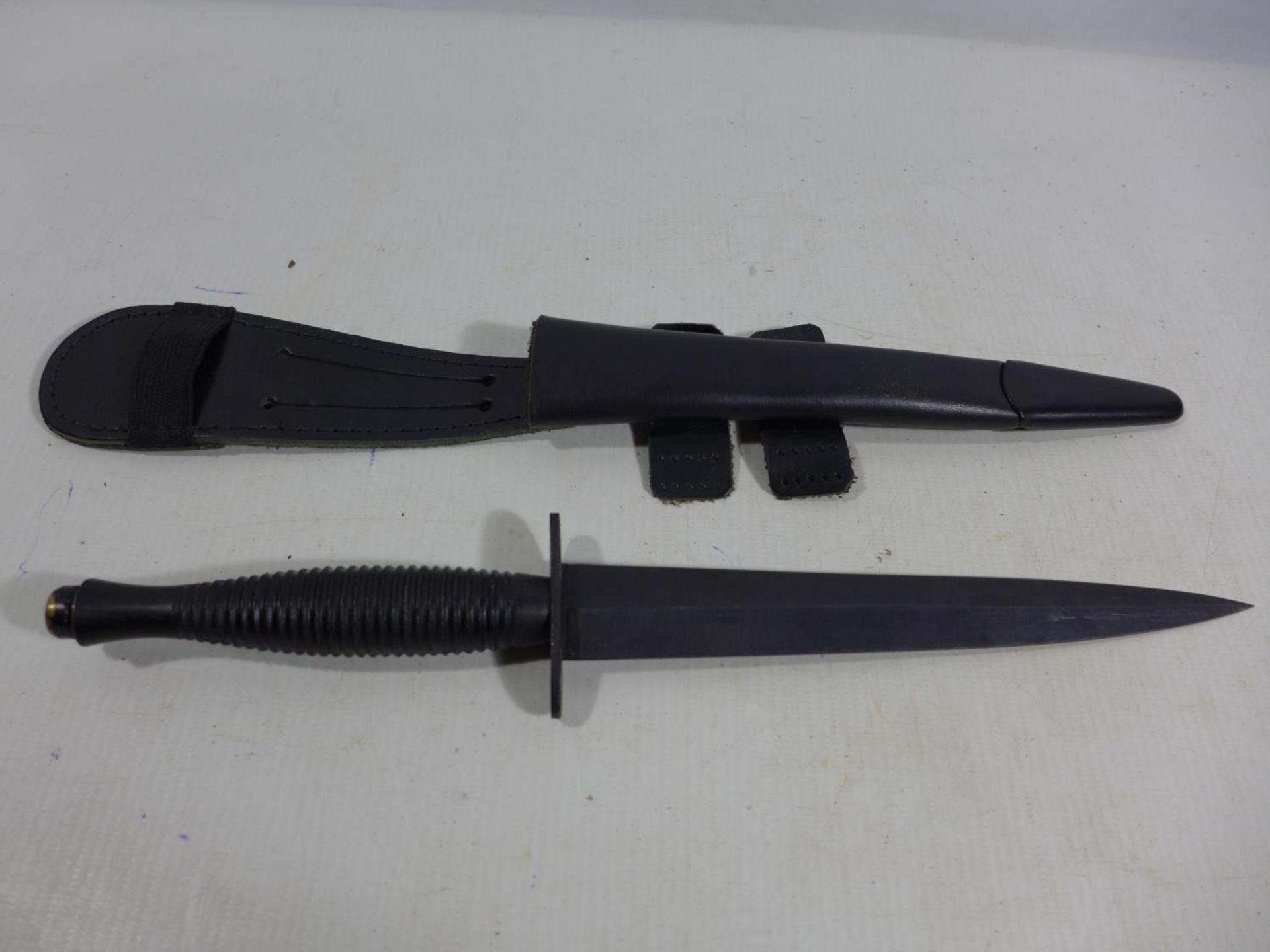 A FAIRBAIRN SYKES FIGHTING KNIFE AND SCABBARD, 18CM BLADE, CROSSGUARD MARKED WITH MILITARY BROAD