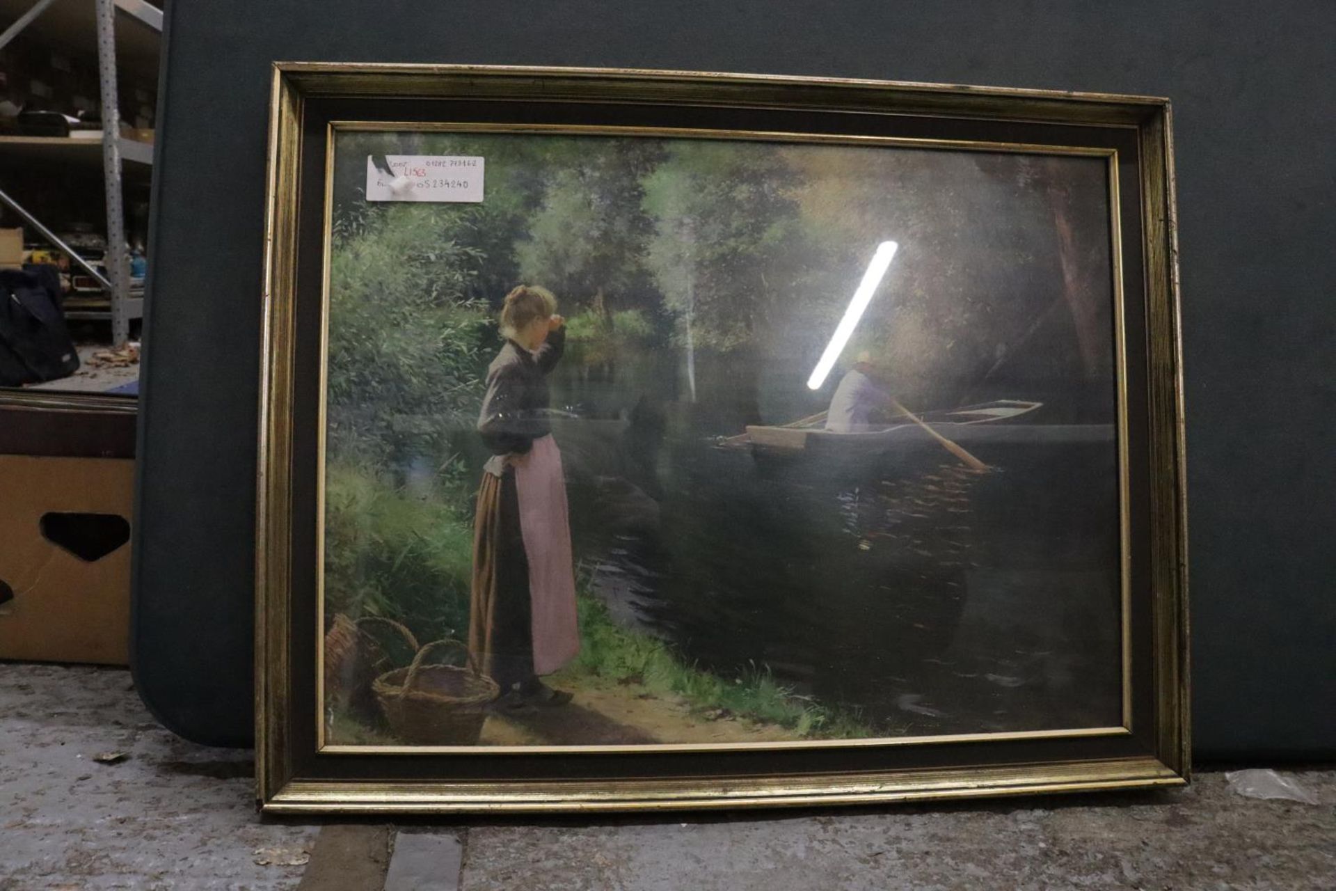 A FRAMED PRINT OF VINTAGE BOATING SCENE ON A LAKE WITH A LADY LOOKING ON, 71CM X 55CM