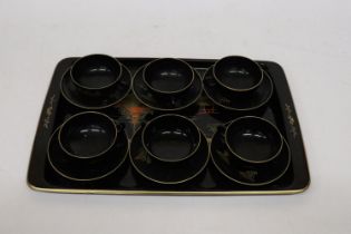 AN ORIENTAL HANDPAINTED, LACQUERED TRAY WITH SIX CUPS AND SAUCERS