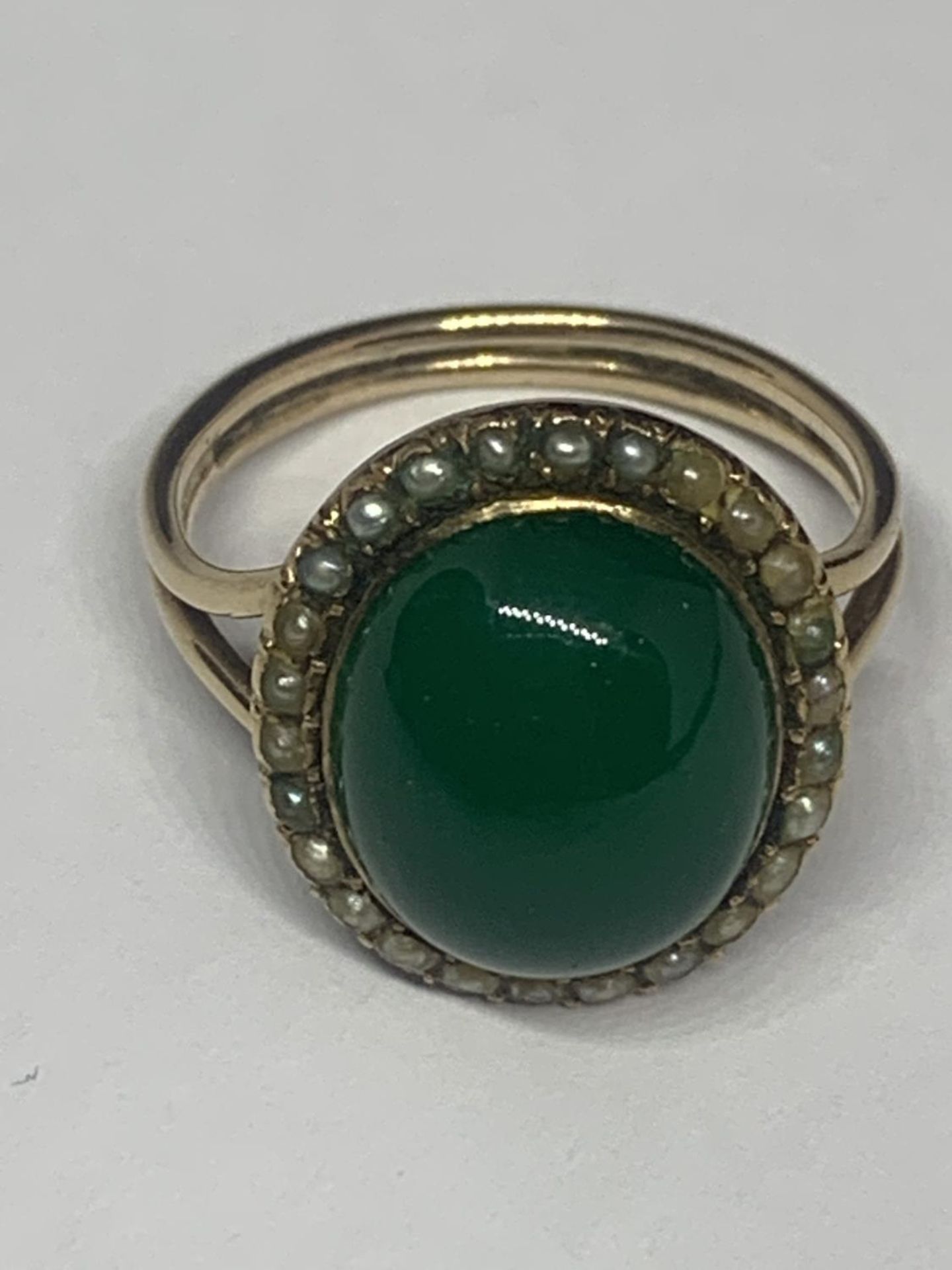 A YELLOW METAL RING WITH GREEN STONE AND PEARLS GROSS WEIGHT 5 GRAMS SIZE M/N