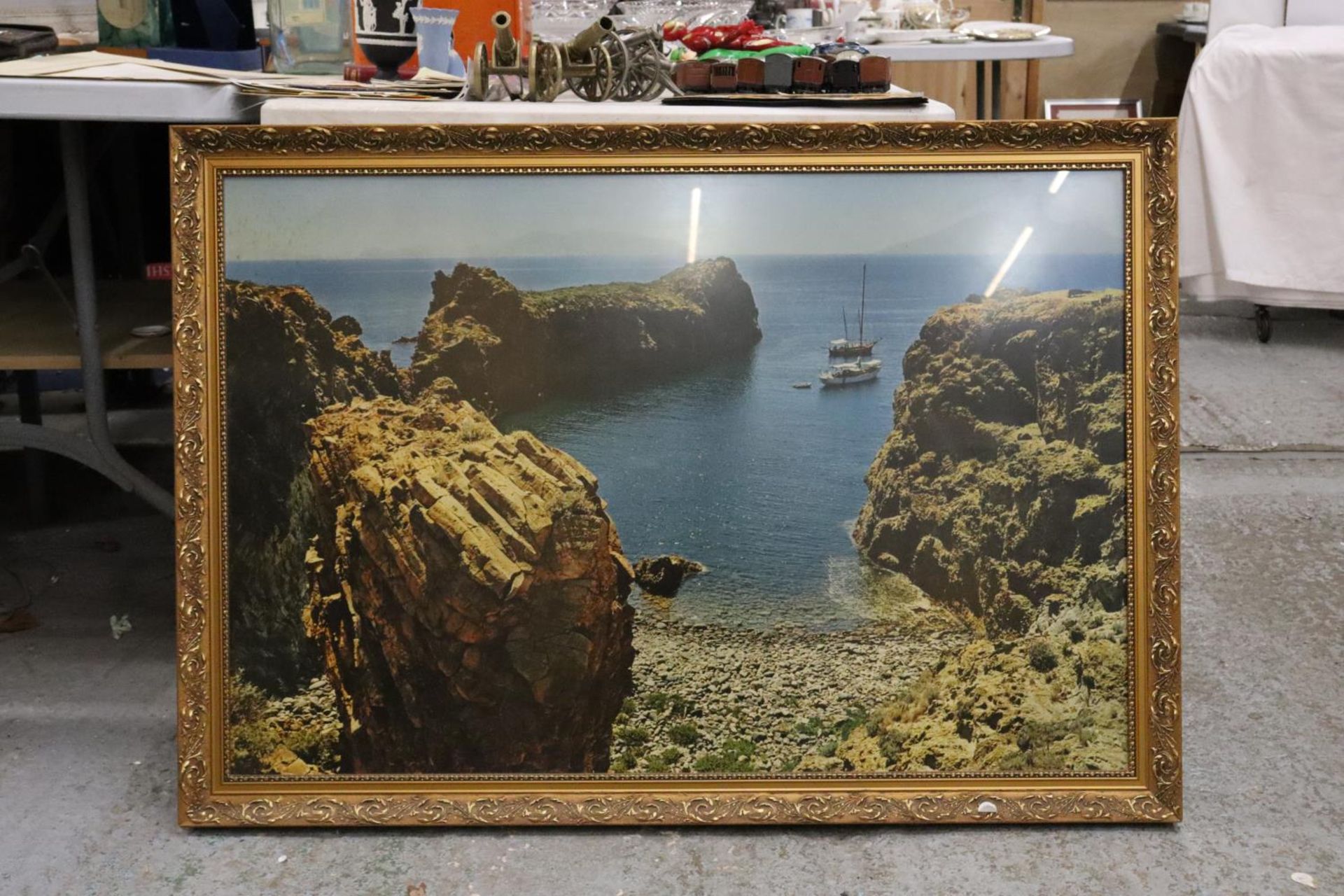 A LARGE FRAMED PRINT OF BOATS NEAR A BEACH