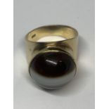 A YELLOW METAL RING WITH TIGERS EYE STONE AND INDISTINCT MARK GROSS WEIGHT 7.95 GRAMS SIZE L/M