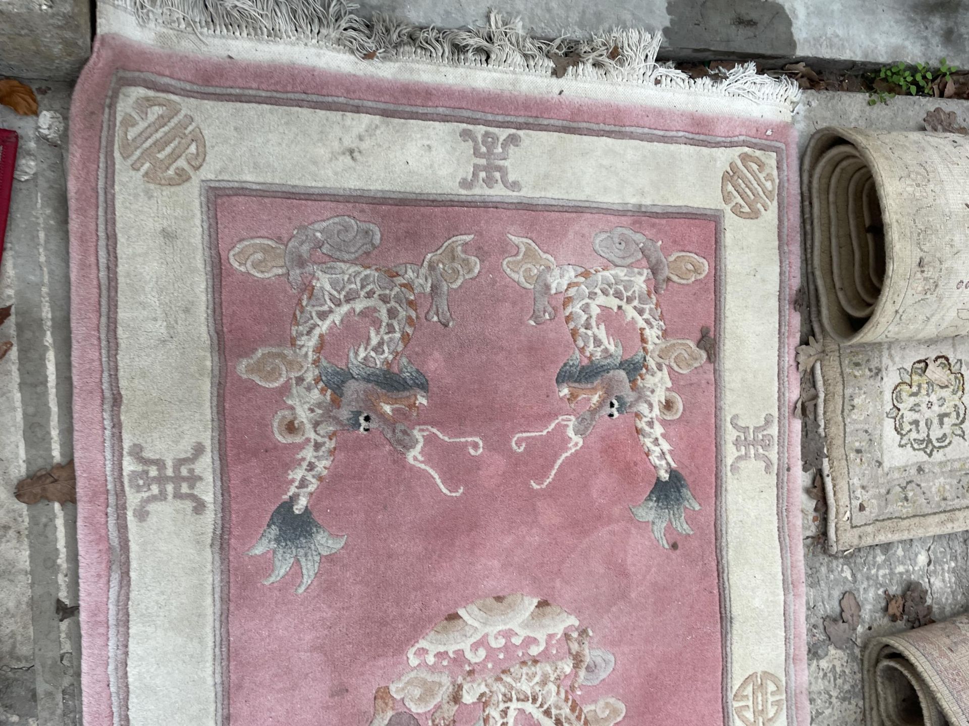 A PINK PATTERNED FRINGED RUG AND A SMALL RED PATTERNED RUG - Bild 2 aus 3