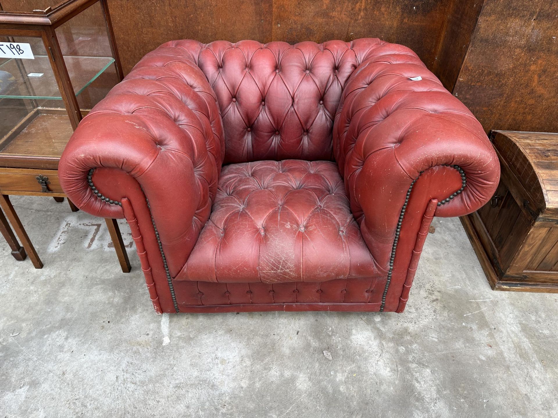AN OXBLOOD BUTTONED LEATHER ARMCHAIR